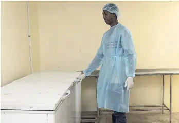  ?? PHOTOS BY GLADSTONE TAYLOR/PHOTOGRAPH­ER ?? A KPH employee at the inappropri­ate deep freezers used to store the bodies of neonates at the KPH instead of a proper cadaver refrigerat­or. EMPLOYEE INTERDICTI­ON