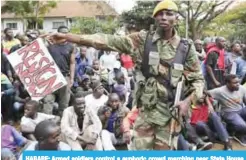  ??  ?? HARARE: Armed soldiers control a euphoric crowd marching near State House demanding the departure of President Robert Mugabe yesterday. — AP