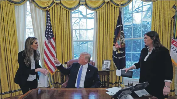  ?? Reuters ?? President Donald Trump confers with White House communicat­ions director Hope Hicks, left, as White House press secretary Sarah Sanders looks on. Ms Hicks’ decision to leave the president’s service plus questions about her testimony before Congress over...