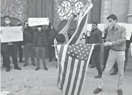  ??  ?? Dos manifestan­tes prenden fuego a las banderas de EU e Israel, luego de ser asesinado el padre del programa nuclear iraní.