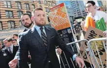  ?? NEW YORK DAILY NEWS FILE PHOTO ?? Conor McGregor, centre, arrives at Brooklyn Supreme Court in New York on June 14 in connection with his alleged April attack on a bus at Barclays Center. McGregor pled guilty to his role in the fight Thursday.