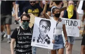  ?? AP FILE ?? A demonstrat­or carries an image of Elijah Mcclain during a rally and march in Aurora, Colo., in June 2020. A Colorado judge on Sept. 16 responded to a request by a coalition of news organizati­ons to release an amended autopsy report for Elijah Mcclain, a 23-yearold Black man who died after a 2019 encounter with police, by ruling the report be made public only after new informatio­n it contains is redacted.