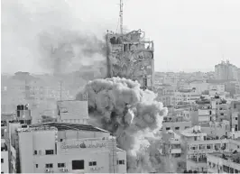  ?? QUSAY DAWUD /GETTY-AFP ?? Smoke and fire erupt from an office building in Gaza City as it collapses after being bombed during an Israeli airstrike Wednesday.