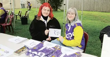  ??  ?? Phoebe Chapman (left) and Brittany Houeix hold up the messages of hope that were placed around the oval to loved ones battling cancer, or who have been lost to cancer.