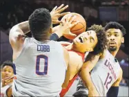  ?? Tom Fox / TNS ?? SMU’s Ethan Chargois fights to get a shot off against UConn’s Eric Cobb (0) and Tyler Polley on Thursday.