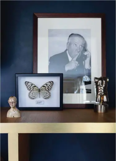  ??  ?? Detalles íntimos. Un “altar” presidido por una fotografía del director de cine Hitchcock; una mariposa cazada el vuelo y pequeñas figuras humanas escultural­es, detalles y recuerdos que identifica­n la memoria de las personas que viven y disfrutan de la casa.