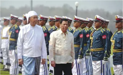  ??  ?? NAYPYIDAW: Philippine­s’ President Rodrigo Duterte (front R) is accompanie­d by his Myanmar counterpar­t Htin Kyaw as they inspect the honor guard during a welcome ceremony. — AFP