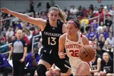  ?? STEVEN SENNE — THE ASSOCIATED PRESS ?? Holy Cross guard Bronagh Power-Cassidy (13) defends as Boston University guard Maggie Pina (22) drives toward the basket in the first half of an NCAA women’s Patriot League college basketball championsh­ip game, Sunday, March 12, 2023, in Boston.