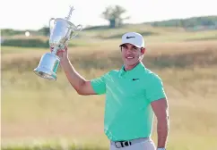  ?? GREGORY SHAMUS / GETTY IMAGES ?? Brooks Koepka with the winner’s trophy after his victory at the 2017 U. S. Open at Erin Hills on Sunday.