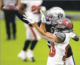  ?? I saac Brekken Associated Press ?? SCOTT MILLER, competing against Raiders cornerback Nevin Lawson, caught six passes for a career- high 109 yards and a touchdown in the Buccaneers’ win.