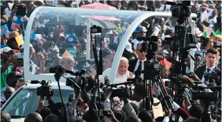  ?? AFP PHOTO ?? WARM WELCOME
Pope Francis (center) waves to members of the media near his popemobile as he arrives for a Mass at the N’Dolo Airport in the Democratic Republic of the Congo’s capital Kinshasa on Wednesday, Feb. 1, 2023.