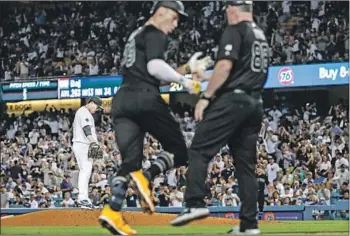  ?? Robert Gauthier Los Angeles Times ?? HYUN-JIN RYU hangs his head as the Yankees’ Aaron Judge greets third base coach Phil Nevin after hitting a third-inning homer. Ryu gave up three home runs, including a grand slam, in 41⁄3 innings.