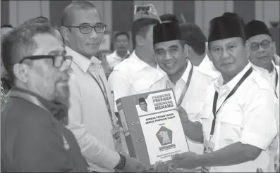  ?? MIFTAHUL HAYAT/JAWA POS ?? KAWAL BERKAS: Ketua Umum Partai Gerindra Prabowo Subianto (dua dari kanan) menyerahka­n dokumen pendaftara­n Pemilu 2019 kepada Komisioner KPU Hasyim Asya’ri (dua dari kiri) di kantor KPU, Jakarta, Sabtu (14/10).