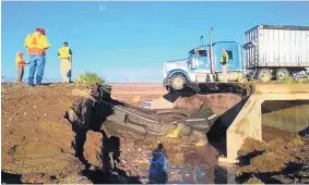  ?? SOURCE: COCONINO COUNTY ?? Workers gather at a washed-out stretch of U.S. 89 near Cameron, Ariz., on Thursday. A collision there killed a woman Wednesday night.