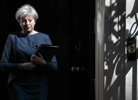  ?? Daniel Leal-Olivas/AFP ?? Theresa May se prepara para fazer pronunciam­ento em frente à residência oficial em Downing Street, em Londres