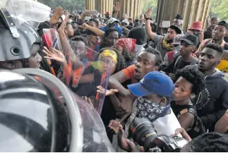  ?? Picture: Neil McCartney ?? NO-GO. A group of protesting Wits students try to push through security guards to get into Solomon Mahlangu Hall yesterday.