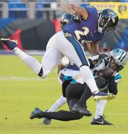  ?? KARL MERTON FERRON/BALTIMORE SUN ?? Ravens cornerback Marcus Peters forces a fumble by Panthers wide receiver Shi Smith during the fourth quarter of Sunday’s game at M&T Bank Stadium.