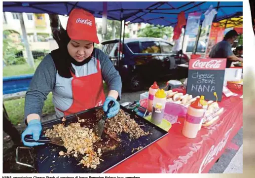  ??  ?? HANA menyiapkan Cheese Steak di gerainya di bazar Ramadan Kelana Jaya, semalam.