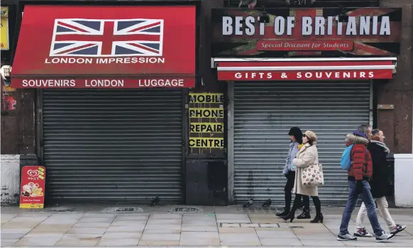  ?? Reuters ?? Closed shops in London. A year ago this week, workplaces and businesses across the country shut their doors to help curb the spread of Covid-19