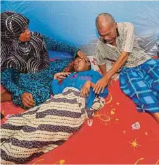  ??  ?? ABDUL Aziz bersama isteri Kartina (kanan), dan anak mereka yang menghidap penyakit saraf di pusat pemindahan SK Bukit Gasing.
