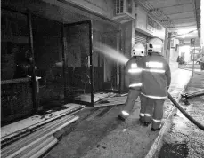  ??  ?? The firefighte­rs putting out the blaze at Fajar Centre.