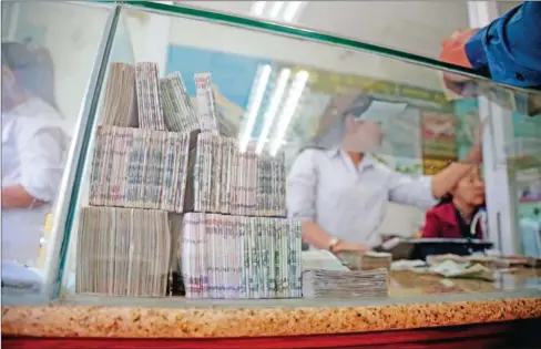  ?? HONG MENEA ?? Bundles of riel banknotes sit on a counter at a Ly Hour Exchange branch in central Phnom Penh yesterday afternoon.
