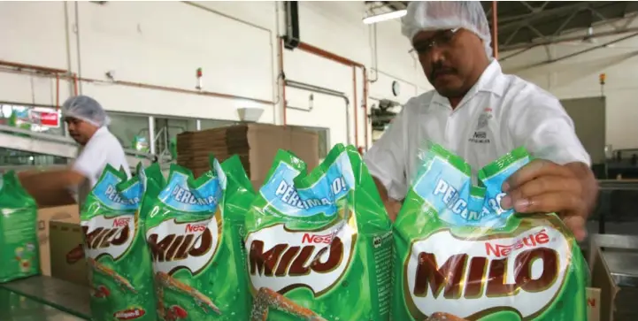  ?? BLOOMBERG ?? Workers packing sacks of Milo drink powder at the Nestlé Malaysia plant in Selangor