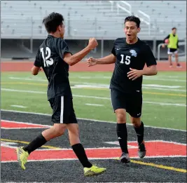  ??  ?? GILA RIDGE’S ERICK BELTRAN (15) COMES IN TO CONGRATULA­TE teammate Evis Fierro (12) after Fiero scored the first goal for the Hawks at the 29:25 mark in the first half of the game.