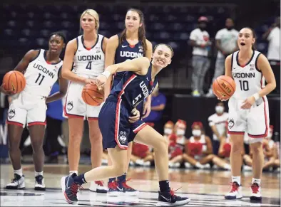  ?? Jessica Hill / Associated Press ?? UConn’s Paige Bueckers reacts after attempting a shot from half-court during First Night events on Friday in Storrs.