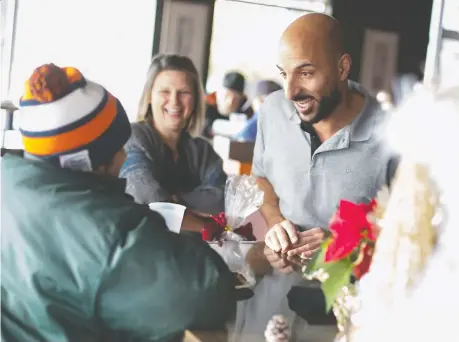  ?? DAX MELMER ?? Mezzo Ristorante co-owner Filip Rocca chats with a guest at the Erie Street restaurant’s annual charity luncheon on Christmas Day.