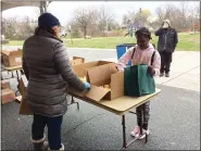  ?? EVAN BRANDT — MEDIANEWS GROUP ?? Barth Elementary School fourth grader Kemyr Isaac chooses a weeks worth of breakfasts and lunches during the district’s food distributi­on efforts Wednesday, with some guidance by Pottstown School Board President Amy Francis.