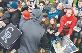  ?? Andy Cross, The Denver Post ?? Fans gather to get an autograph from shortstop Trevor Story during the Rockies’ first day of full-squad workouts Monday.