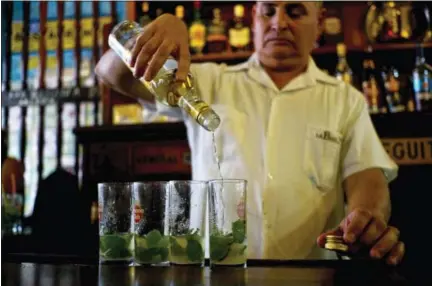  ?? THE ASSOCIATED PRESS ?? A bartender pours Cuban Havana Club rum to prepare mojitos at the Bodeguita Del Medio bar in Havana, Cuba. The agency that controls Pennsylvan­ia’s state-owned wine and liquor stores is working to lift the embargo on Cuban rum.