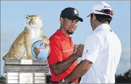  ?? CHRISTIAN PETERSEN / GETTY IMAGES ?? Tournament host Tiger Woods (4-under 284) congratula­tes winner Hideki Matsuyama (18-under 270) after the Hero World Challenge.