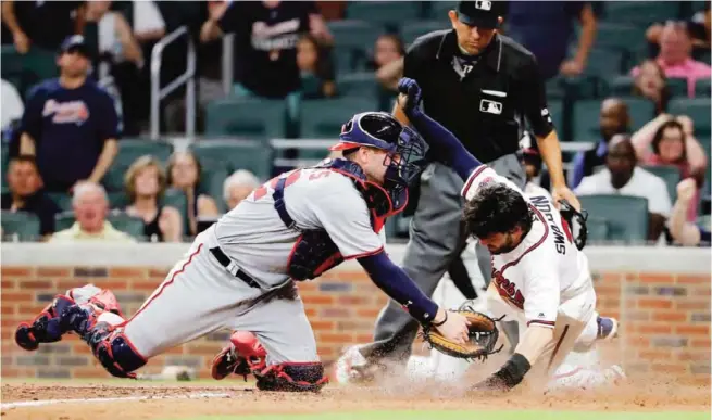  ?? — AP ?? ATLANTA: Atlanta Braves shortstop Dansby Swanson, right, is tagged out at home by Washington Nationals catcher Matt Wieters while trying to score on a single by teammate Ender Inciarte in the sixth inning of a baseball game.