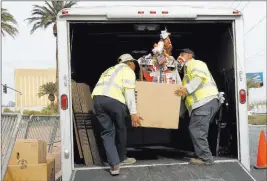  ??  ?? Clark County employees load crosses and items onto a truck Sunday at the Route 91 Harvest memorial at the Welcome to Fabulous Las Vegas sign.