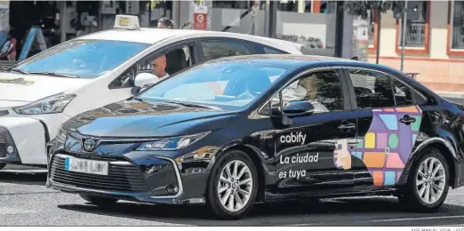  ?? JOSÉ MANUEL VIDAL / EFE ?? Un cabify circula junto a un taxi en las calles de Sevilla.