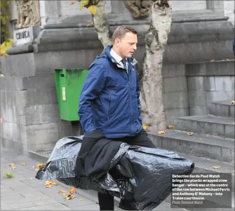  ?? Photo Domnick Walsh ?? Detective Garda Paul Walsh brings the plastic wrapped crow banger – which was at the centre of the row between Michael Ferris and Anthony O’ Mahony – into Tralee courthouse.