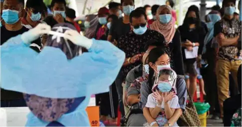  ??  ?? PENUMPANG yang baru tiba dari Sabah menunggu giliran untuk ujian swab Covid-19 di Hospital Labuan, semalam.