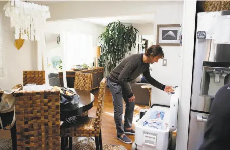  ?? Lea Suzuki / The Chronicle ?? John Kuch and his family store their food in a cooler on ice during the power outage at their house in Mill Valley.