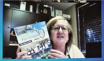  ??  ?? Board Chair Helen Arnold shows the 20th anniversar­y commemorat­ive annual report to video conference participan­ts during the Dr. Noble Irwin Regional Healthcare Foundation annual general meeting, May 7.