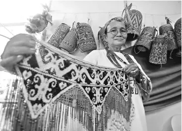  ??  ?? Ama Langat of Uma Kelap at Sungai Asap in Belaga displays an intricatel­y-designed bead necklace that she made by hand.