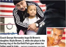  ?? | SANTIAGO COVARRUBIA­S/ SUN- TIMES ?? Coach George Hernandez hugs Ed Brown’s daughter, Kayla Brown, 3, while she plays in the boxing ring at the Garfield Park gym where her father used to train.