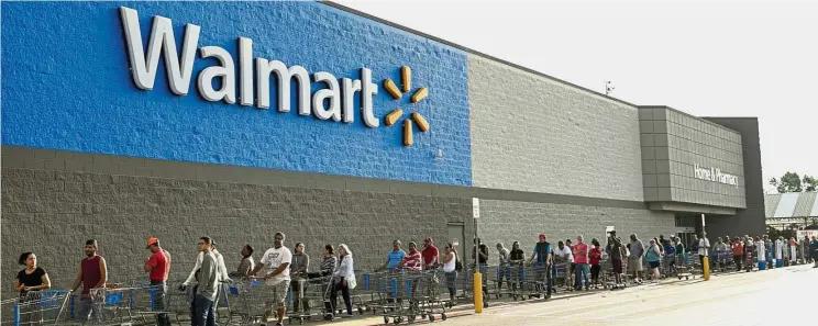  ??  ?? Rivalry in delivery: A long line of people at Walmart in Beaumont, Texas. Taking over some responsibi­lity for delivery enables Amazon to protect that edge as rivals like WalMart Stores Inc enhance their own delivery operations. — AP
