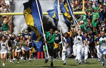  ?? PAUL SANCYA / ASSOCIATED PRESS ?? Notre Dame cheerleade­rs lead the team onto the field for Saturday’s game against New Mexico in South Bend, Indiana. The Georgia Bulldogs had a historic road win in their 2017 meeting with the Fighting Irish.