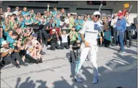  ?? ap pHoto ?? Mercedes driver Lewis Hamilton, foreground, takes a photo as he celebrates his win in the Formula One U.S. Grand Prix auto race at the Circuit of the Americas on Sunday in Austin, Texas.