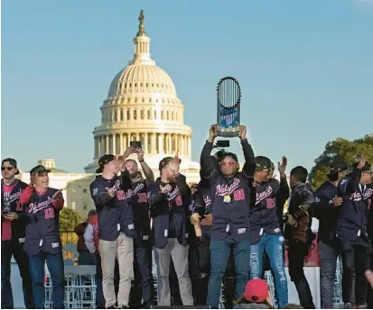  ?? JOSE LUIS MAGANA/AP ?? Nationals players raise the World Series trophy during a parade in Washington on Nov. 2, 2019.