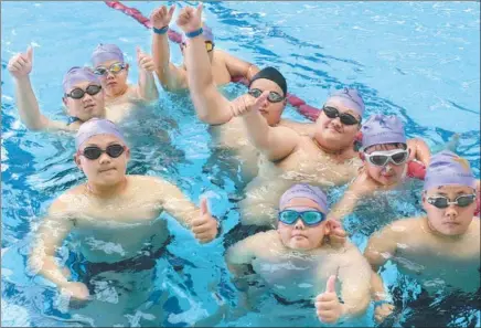  ?? ZHANG TAO / FOR CHINA DAILY ?? Children prepare for weight-loss swimming workout at a boot camp in Zhengzhou, Henan province.