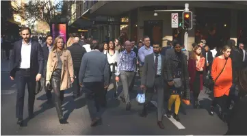  ?? — AFP photo ?? People crossing a road in the central business district of Sydney.