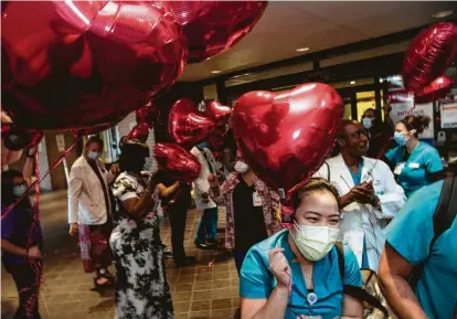  ?? Photos by Brett Coomer / Staff photograph­er ?? In honor of National Nurses Week and kicking off National Nurses Day, night-shift nurses are cheered and given balloons as they leave work at Baylor St. Luke’s Medical Center.